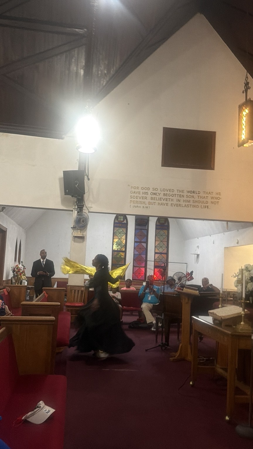 A praise dancer ministering with gold fabric in a church