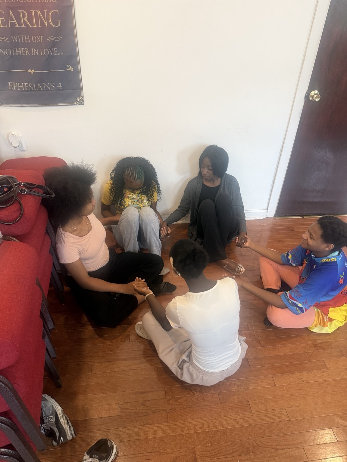 Ministry members holding hands together in a prayer circle